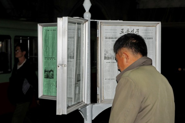 Житель Северной Кореи читает газету на станции метро